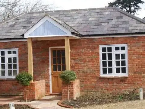 Finished red-brick extension with a hipped roof and oak porch posts