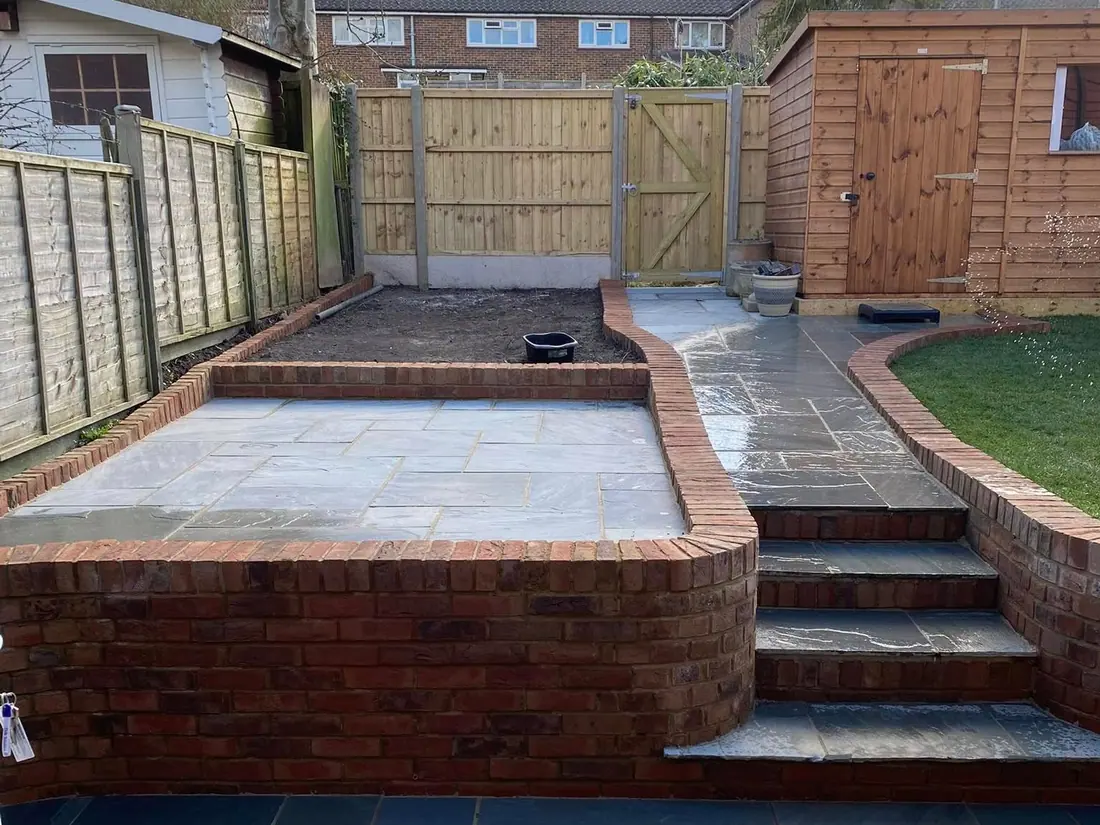 New red-brick steps and retaining wall leading up to a raised lawn